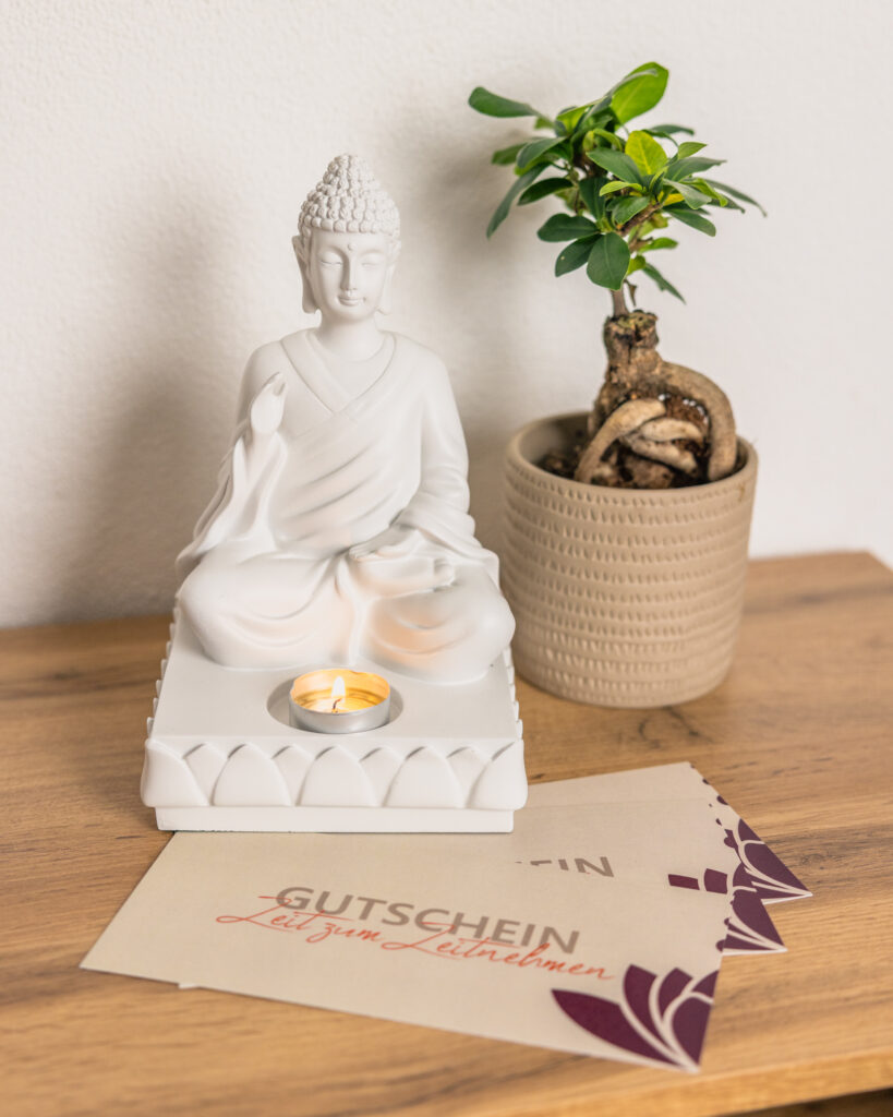 Gutscheine neben einer Buddhafigur.